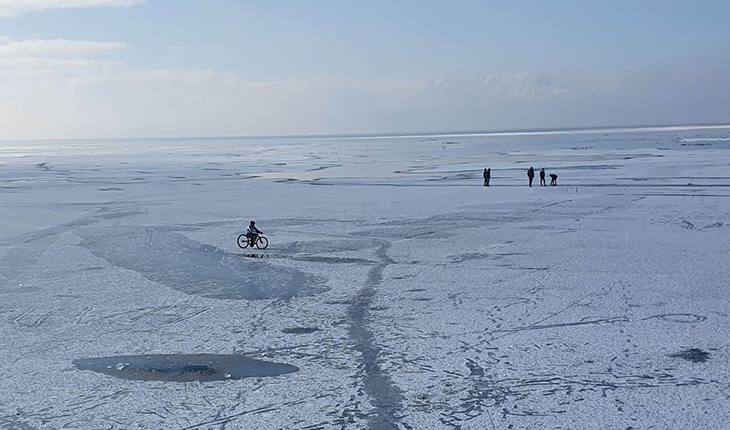 Buz tutan gölde tehlikeye rağmen yürüyüp bisiklet sürdüler