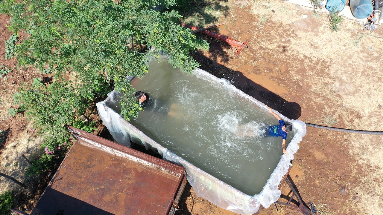 Bir çiftçi sıcaktan bunalan çocukları için traktörünün römorkunu havuza çevirdi