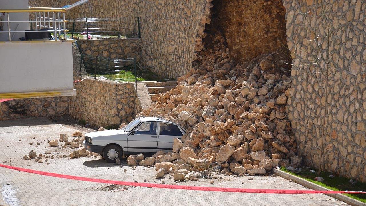 Park halindeki otomobil yıkılan istinat duvarının altında kaldı