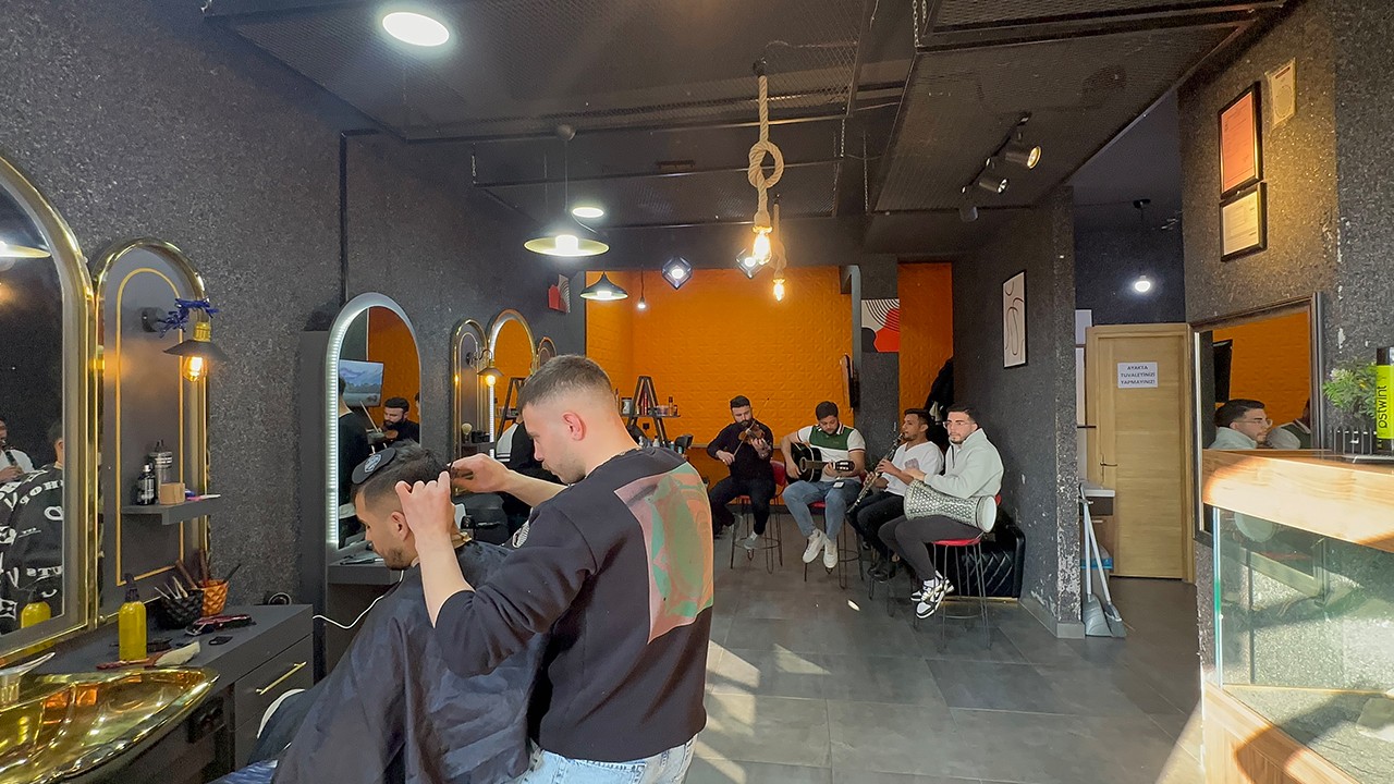 Müşterilerini keman, gitar, klarnet ve darbuka eşliğinde tıraş ediyor