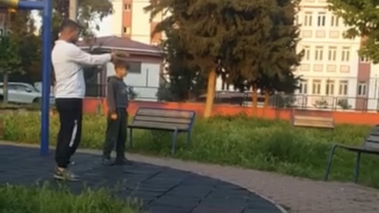 Parkta çocuğa oyuncak silahla atış talimi yaptırdı