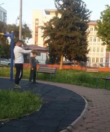 Parkta çocuğa oyuncak silahla atış talimi yaptırdı